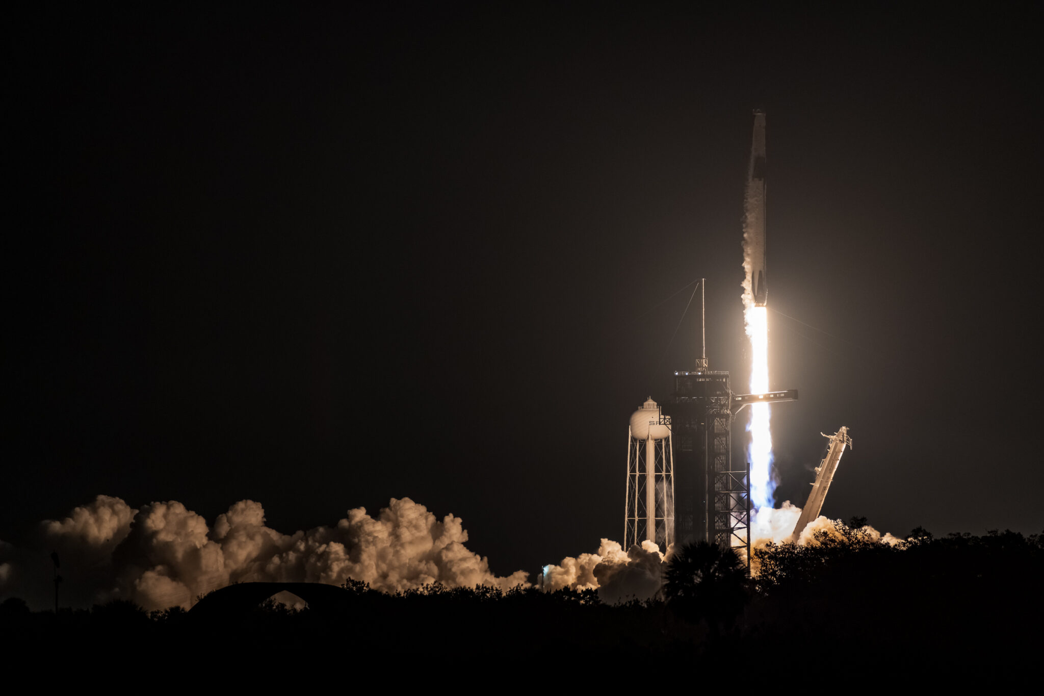 Close up of Falcon 9 lifting off from LC-39A with the plume illuminated by the rocket exhaust.