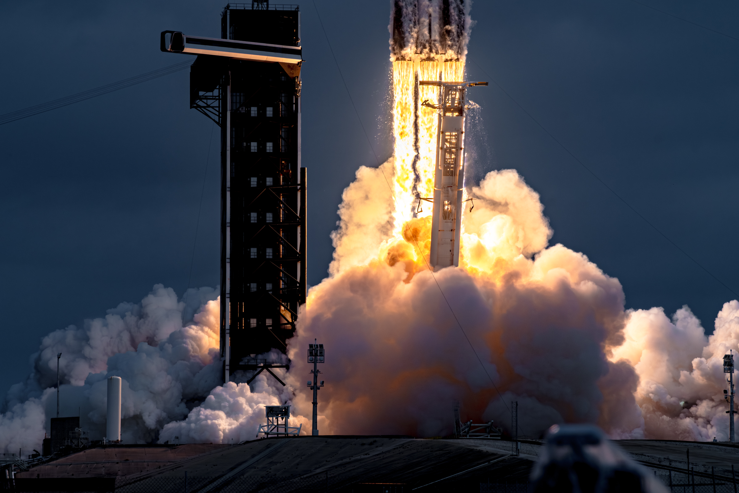 A medium shot of Falcon heavy lifting off from 39A. The exposure of the image is darker to allow for flame details.
